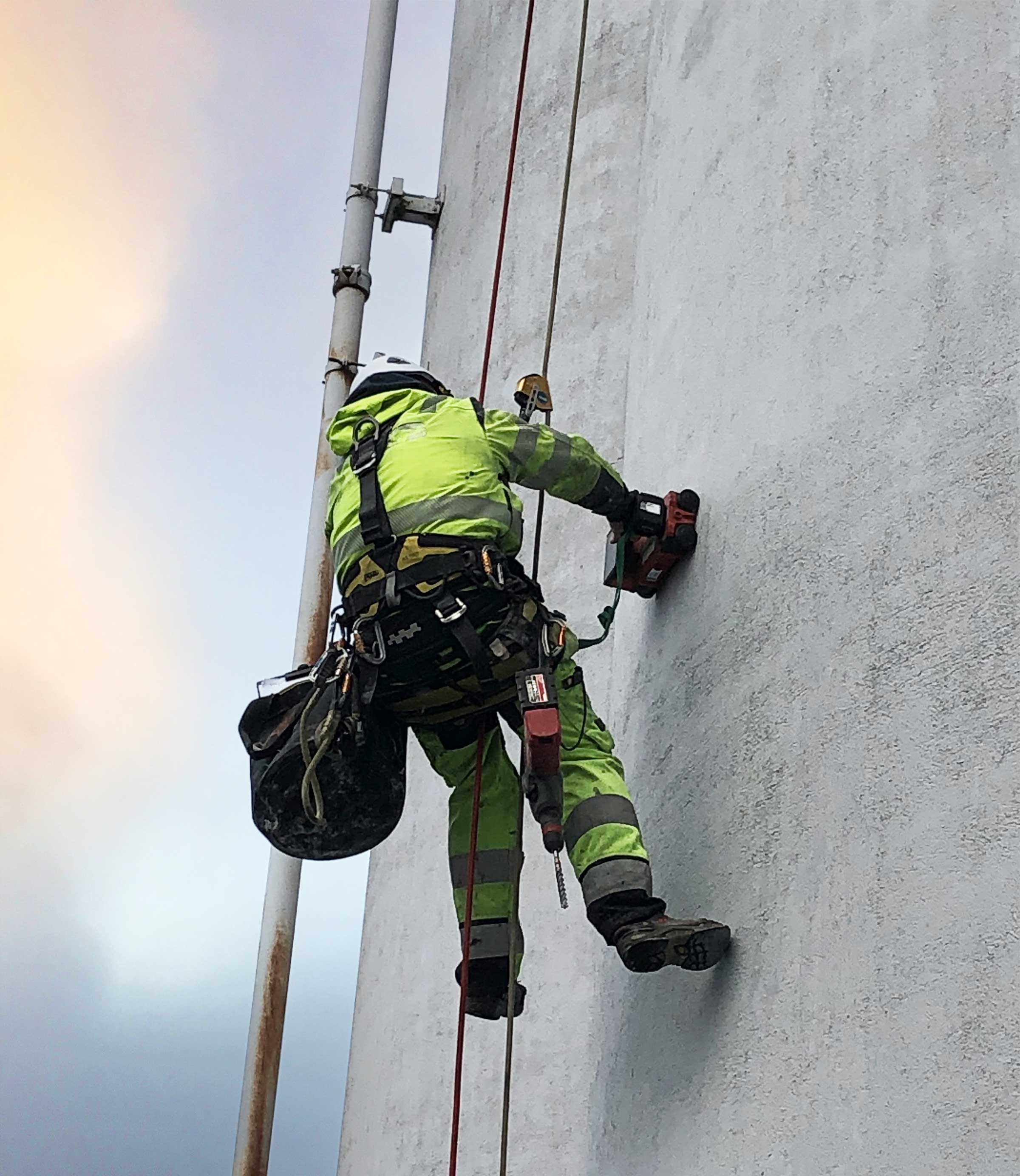 bild på hängande arbetare i sele mot fasad