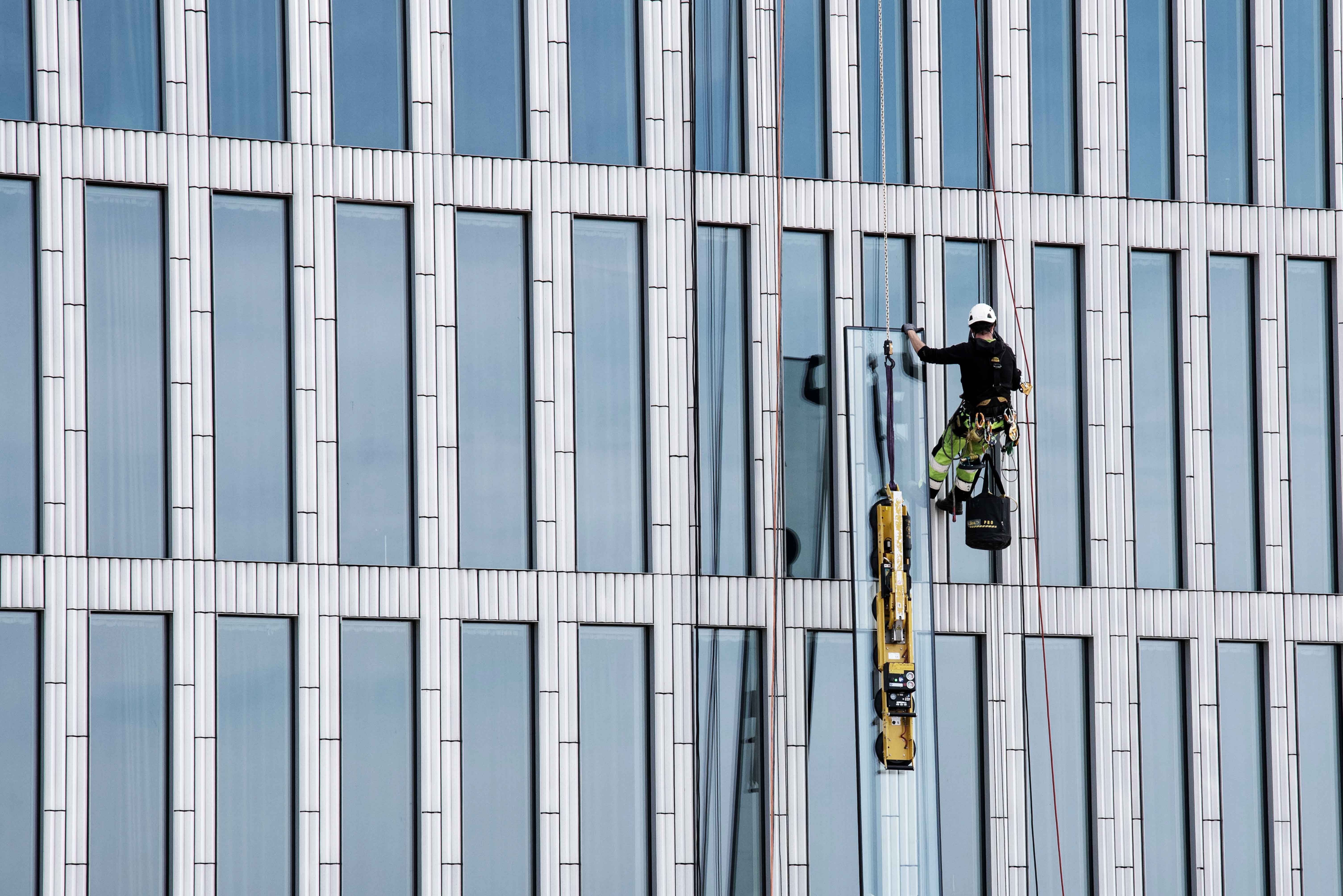 fönstermontage utfärdas av man hängandes i sele
